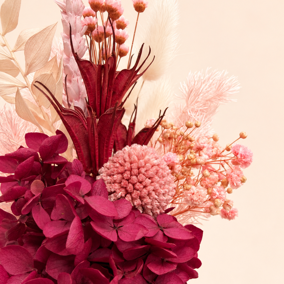 Pink dried flower arrangement with deep maroon florals