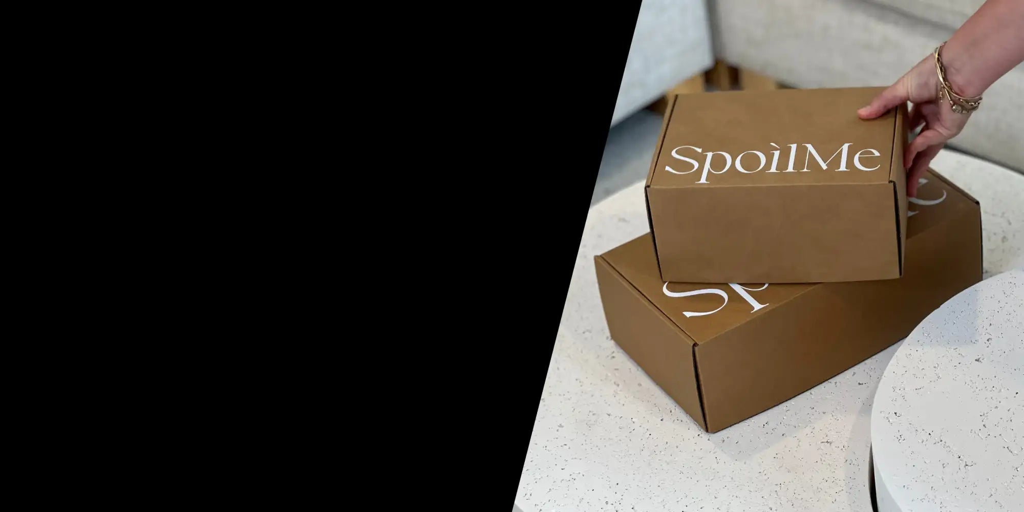 Brown cardboard box with ’spoilme’ printed in white script.