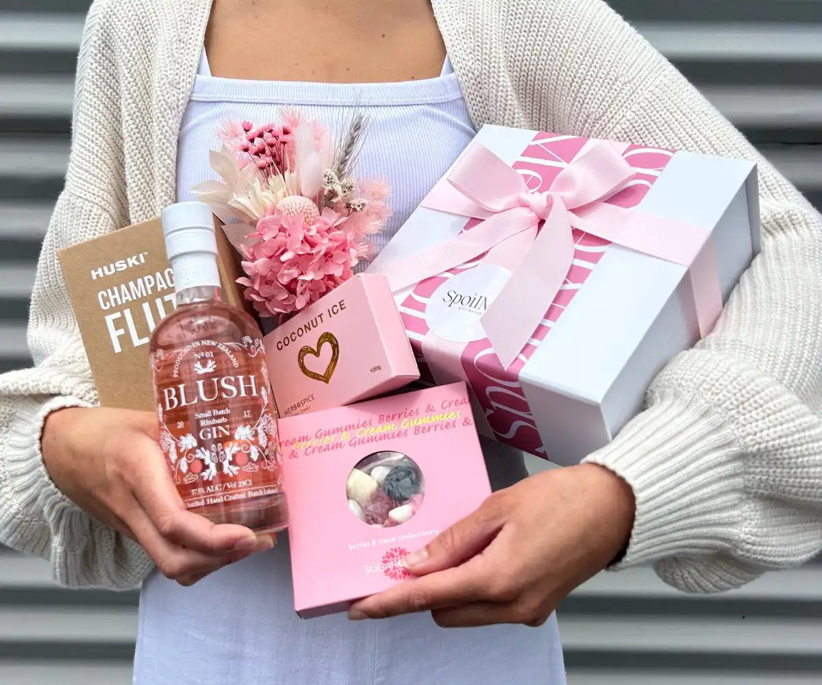 Pink glass bottle of blush gin with floral label and white cap