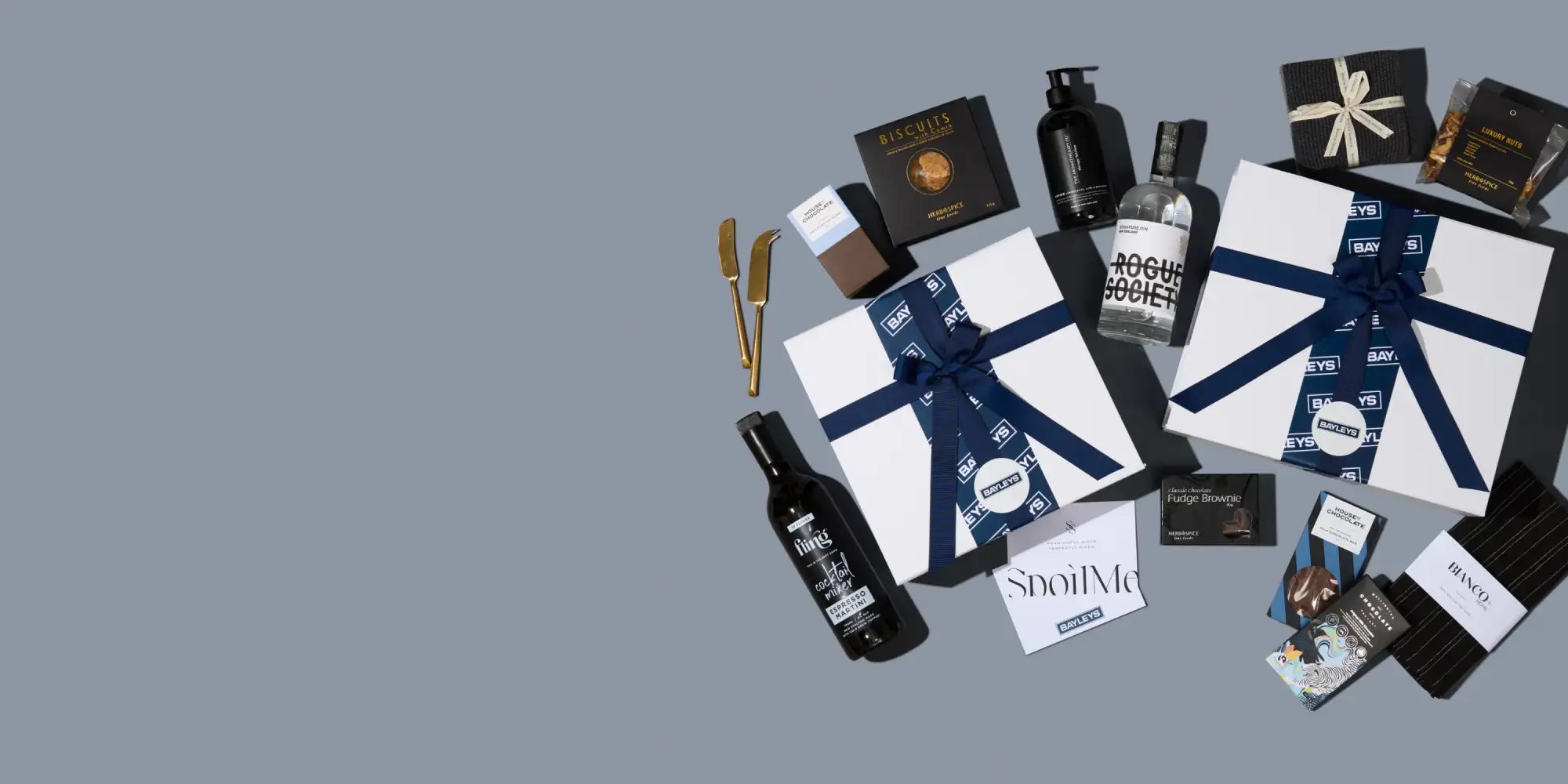 Two white gift boxes with navy blue ribbons and branded packaging.