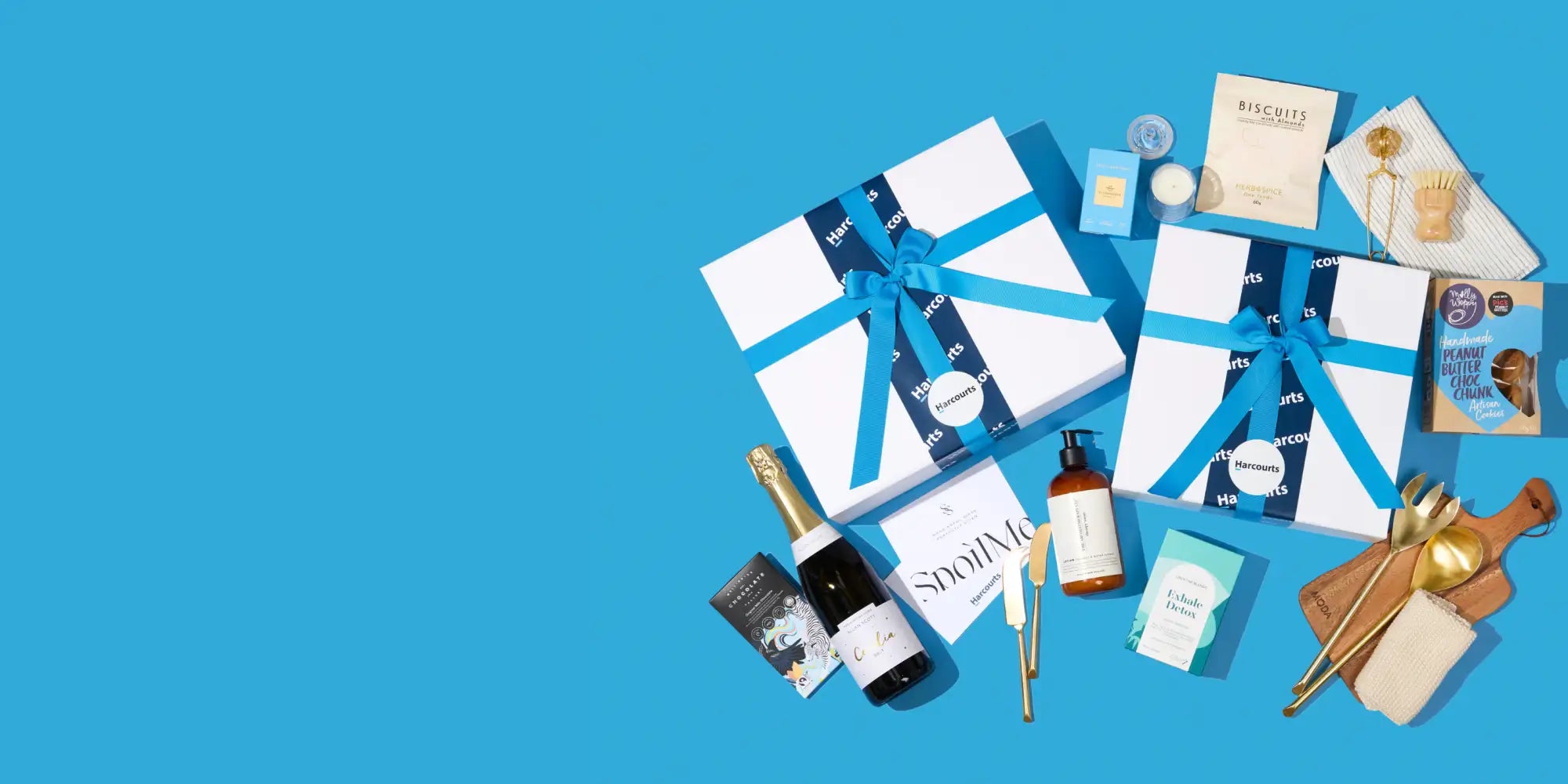 Two white gift boxes tied with blue ribbons, each featuring a circular logo and the word ’biscuits’ printed on them.