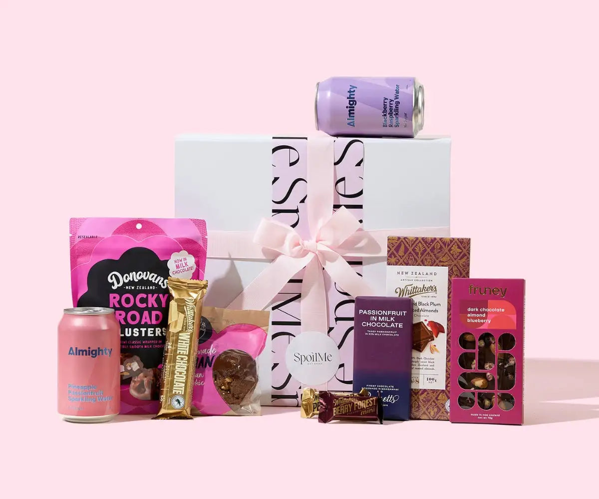 A white gift box with a pink ribbon bow and black lettering, topped by a purple can of almighty sparkling water.