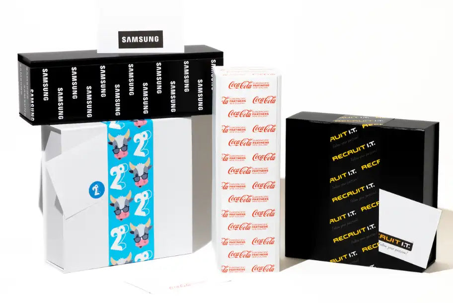 White rectangular box with blue tape featuring cartoon cows wearing sunglasses and the number ’2’’ printed repeatedly.